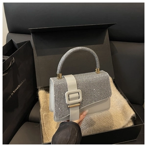 Détail d'un sac à main de luxe orné de strass avec boucle carrée dans son coffret cadeau