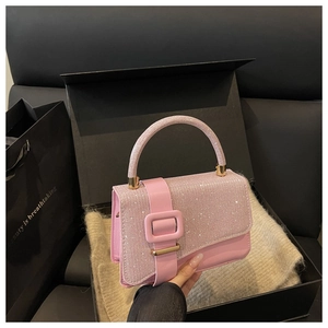 Détail macro du sac en cuir rose avec rabat en strass étincelants et finitions dorées