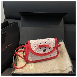Détail du sac bandoulière bicolore dans un coffret cadeau avec pendentif en cœur