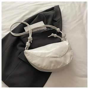 Détail du sac à main crème avec bandoulière à nœuds et perles translucides