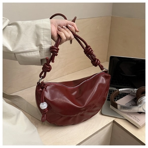 Détail du sac lune bordeaux avec sangle nouée, perle de marbre et fermeture éclair
