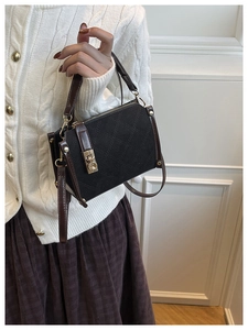 Close-up of diamond quilted shoulder bag with gold metal lock and leather texture detail