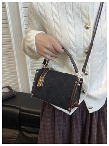 Detail of crossbody bag featuring quilted rhombus stitching and gold hardware locks