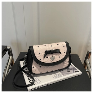 Détail du tissu froissé rose avec nœuds noirs et pendentif cœur en métal