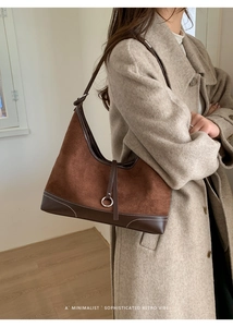 Detail of retro tote bag showing brown suede and leather stitching with white topstitching