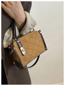 Detail of a retro quilted crossbody bag with rhombus texture and gold metal buckle