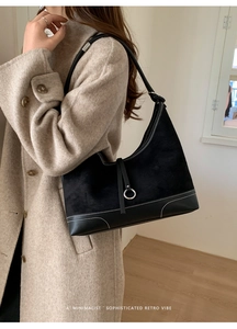 Detail view of the black retro shoulder bag featuring white contrast stitching and metal ring