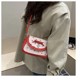 Détail du sac à bandoulière rose avec nœud, pendentif cœur et motif floral sur le mannequin