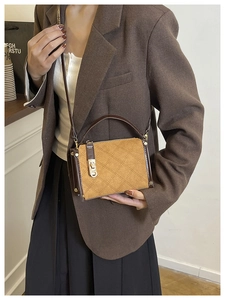 Detail of a vintage quilted square crossbody bag with gold hardware and rivet accents