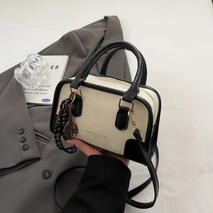 Chic two-tone Boston shoulder bag with tennis racket charm and black handles