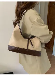 Detail of minimalist tote bag with contrast stitching and metal ring buckle on shoulder strap