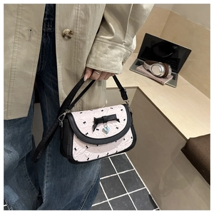 Détail du sac à motif nœuds avec pendentif cœur bleu et nœud 3D élégant