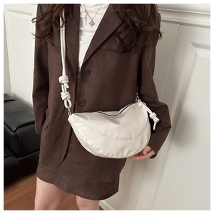 Détail du sac croissant en cuir PU blanc avec surpiqûres et bandoulière à nœud