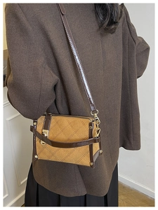 Detail of suede crossbody bag with rhombus stitching and elegant gold metal lock