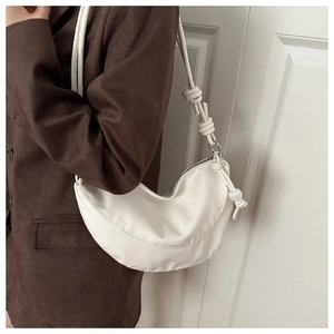 Détail du sac hobo croissant blanc avec bandoulière à nœud et breloque perle élégante