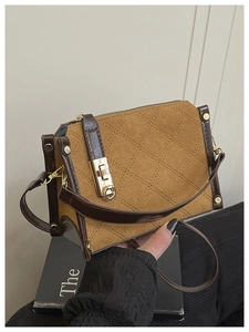 Detail of the diamond-quilted pattern and golden square lock on the camel crossbody bag