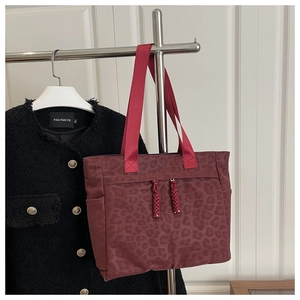 Détail du sac cabas léopard bordeaux avec tirettes tissées et multiples poches de rangement