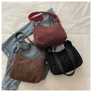 Three leopard print crossbody bags in burgundy, brown, and black on a denim jacket