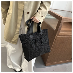 Détail du sac cabas léopard noir avec cordons de serrage et poches latérales sur modèle