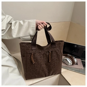 Détail du grand sac cabas à imprimé léopard avec glands à franges tressées et poche latérale