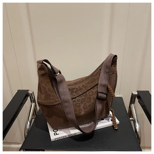 Détail du sac bandoulière léopard avec large sangle tissée et tirettes de fermeture