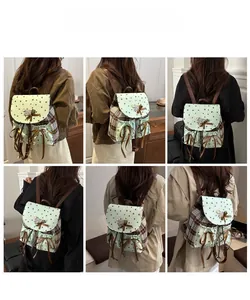 Detail view of mint green backpack with bow and star print on model back