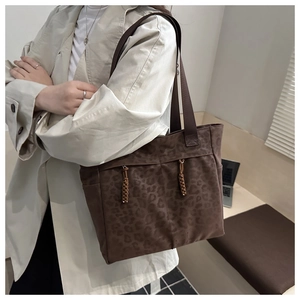 Detail view of large leopard print tote bag with woven drawstrings and side pockets