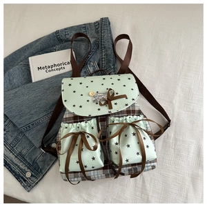 Detail of plaid mint green backpack with star patterns and decorative silk bows