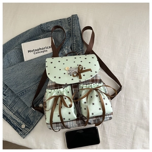 Detail view of the mint green bow backpack with star patterns and checkered fabric