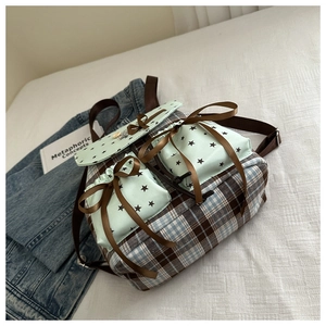 Detail of plaid student backpack with green star pockets and decorative brown bows