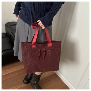 Vue détaillée du sac cabas léopard bordeaux avec sangle tissée et poche latérale