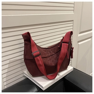 Détail du sac hobo léopard rouge foncé avec cordon tressé sur la fermeture éclair