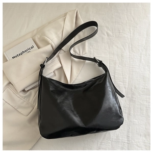 Dettaglio della borsa tote in pelle PU nera con tracolla regolabile e fibbia in metallo