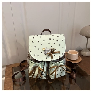 Close-up of mint green mini backpack featuring star prints and satin bow details