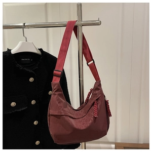 Détail du sac bandoulière bordeaux en nylon avec motif léopard et tirette tissée