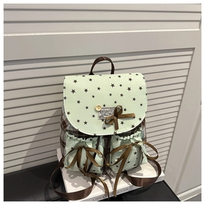 Detailed view of mint green backpack featuring star patterns and brown ribbon bows