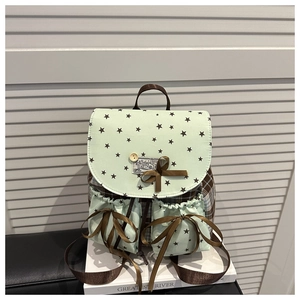 Detail of mint green plaid backpack with star patterns and brown ribbon bow decoration