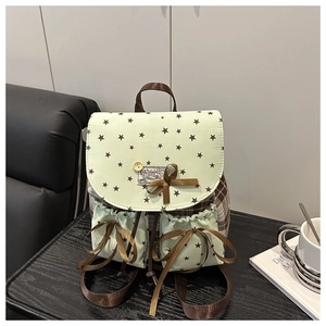 Detail of mint green star pattern backpack featuring bow ribbon and plaid stitching