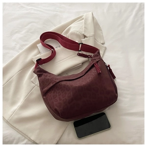 Détail du sac bandoulière bordeaux motif léopard avec bandoulière textile et tirette tressée