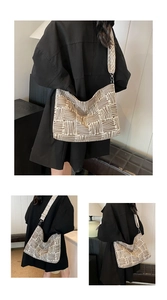 Detail view of large checkered canvas tote bag with adjustable wide strap and silver buckle