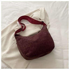 Détail du sac hobo léopard bordeaux avec bandoulière réglable et accessoires de style