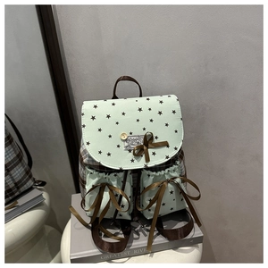 Detail of mint green backpack with bow accents and star pattern on a display stand