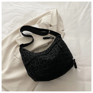 Détail d'un sac hobo à imprimé léopard avec bandoulière réglable sur un magazine ART