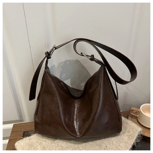 Dettaglio della borsa hobo vintage marrone scuro con pelle lucida e fibbia in argento