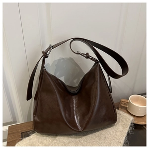 Dettaglio della borsa hobo marrone scuro con texture pelle oliata e fibbia argento