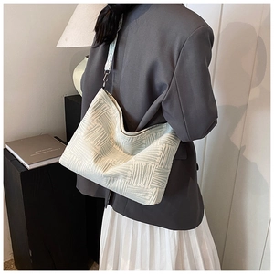 Close-up of light green woven canvas tote bag showing textured fabric and wide shoulder strap