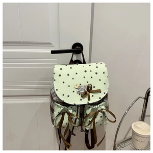 Detail of mint green backpack with brown ribbon bow and star print pattern