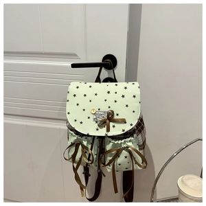 Detailed side view of mint green mini backpack featuring brown plaid panels and star patterns
