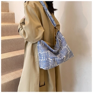 Detail view of blue and white striped canvas tote bag with adjustable shoulder strap