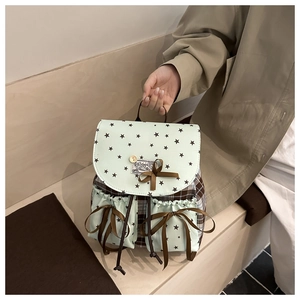 Detail of green star print oxford backpack with brown bows and vintage button detail